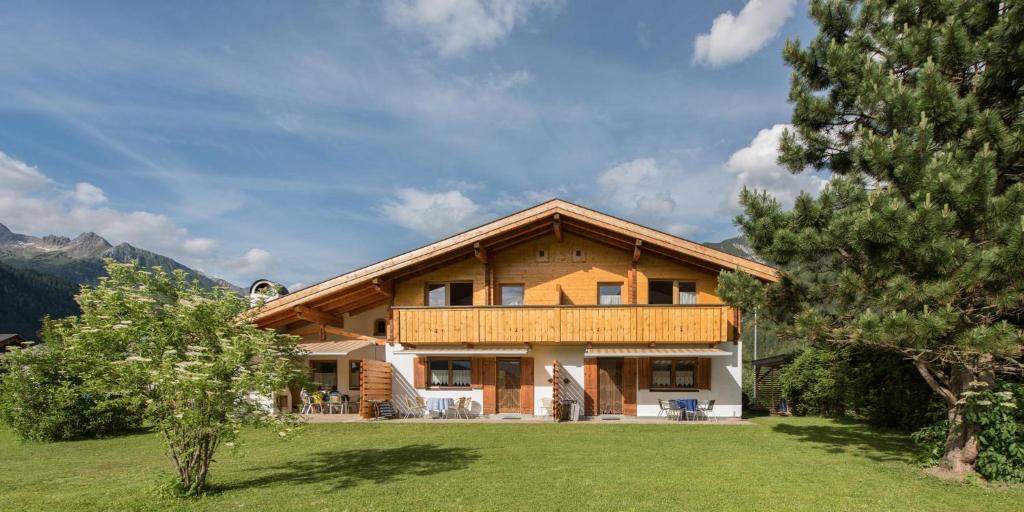 een groot houten huis met een groene tuin bij Haus Barbara in Bach