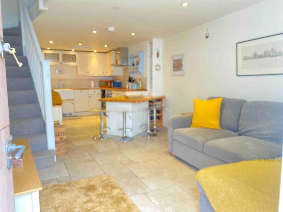 a living room with a couch and a kitchen at High end cottage in amazing location. Only 1 minute from the sea! Beautifully decorated 3 level home. 5* reviews in Lyme Regis