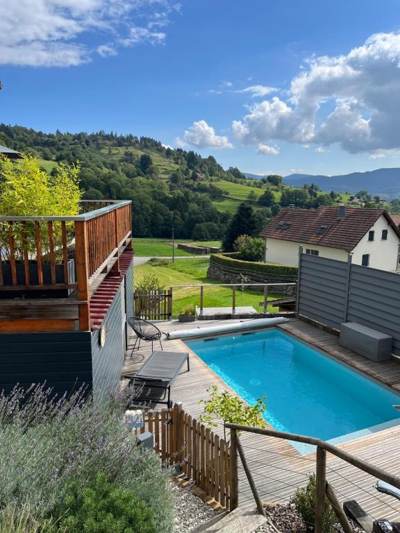 a swimming pool in a yard with a deck at Le chalet de cathy in Soultzeren