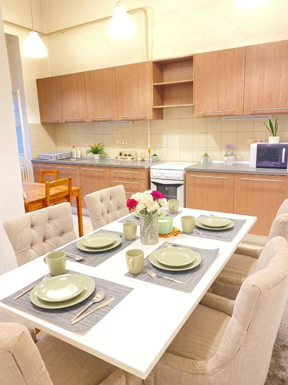 eine Küche mit einem Tisch mit Tellern und Blumen darauf in der Unterkunft Sziv Apartment - Modern and Comfortable in Budapest