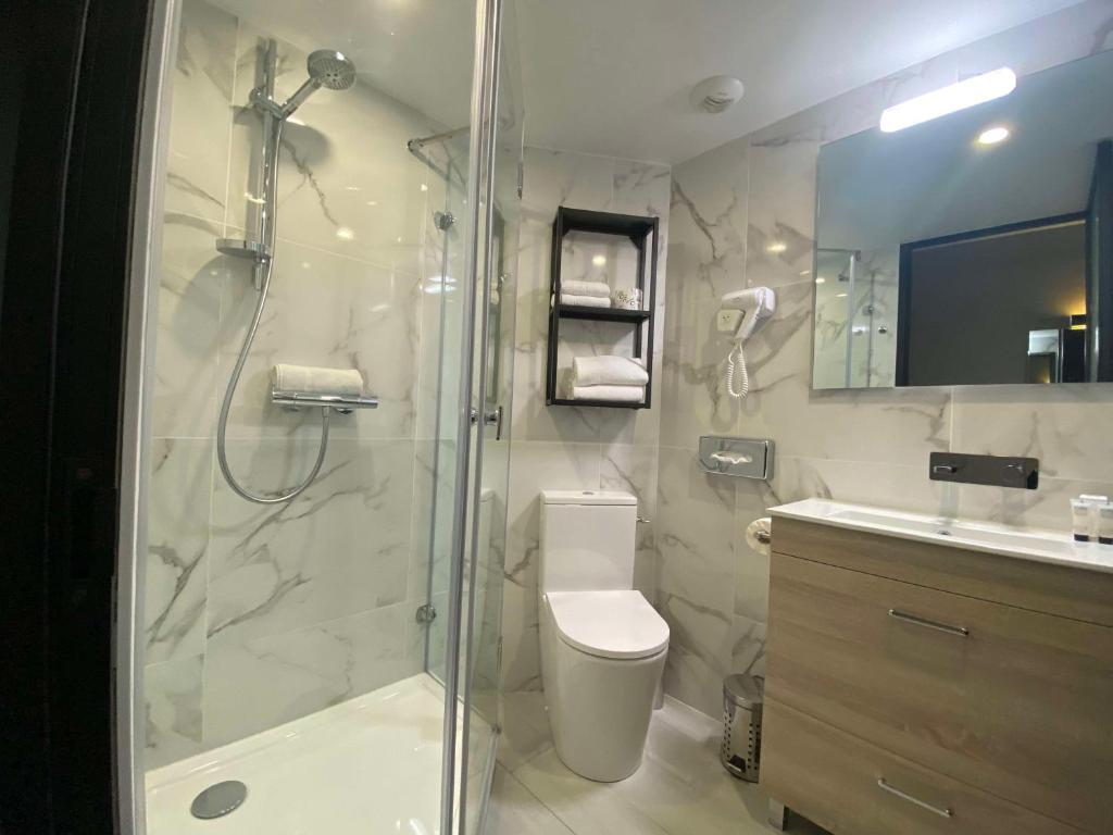 a bathroom with a shower and a toilet and a sink at Hotel Best Western La Mare Ô Poissons in Ouistreham