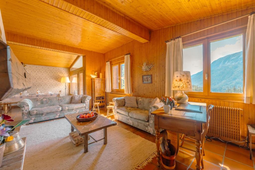 a living room with a couch and a table at Chalet Corzelet ski in - ski out - Happy Rentals in Chamonix-Mont-Blanc