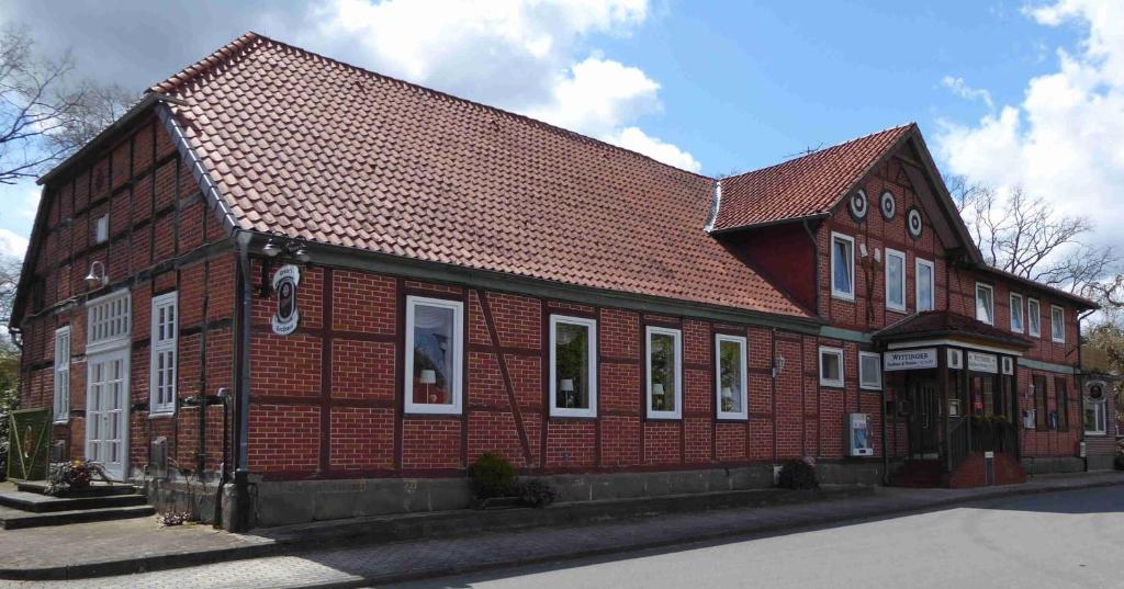 een groot gebouw van rode baksteen met een bruin dak bij Landgasthof Lüder in Lüder