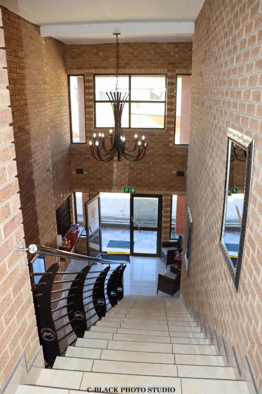 a staircase in a building with a chandelier at Meet Mekaar Resorts - Nquthu Hotel in Nqutu
