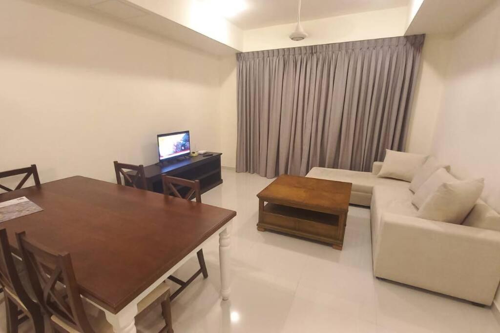 uma sala de estar com um sofá, uma mesa e uma televisão em Capital TRUST Residencies Kotte em Sri Jayewardenepur- Kotte