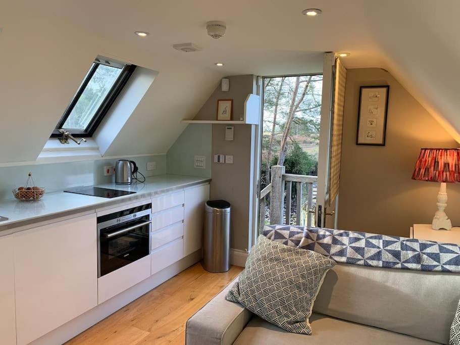 a living room with a kitchen and a couch at Annexe near Malmesbury / Tetbury in Hankerton