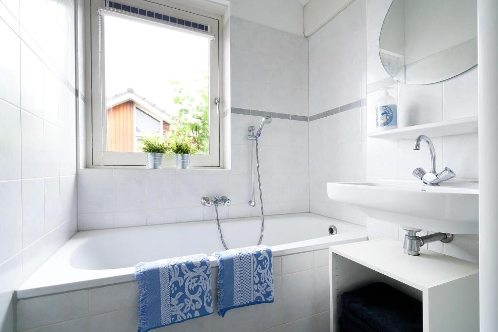 biała łazienka z wanną i umywalką w obiekcie Boathouse Suburban Amsterdam w mieście Uitgeest