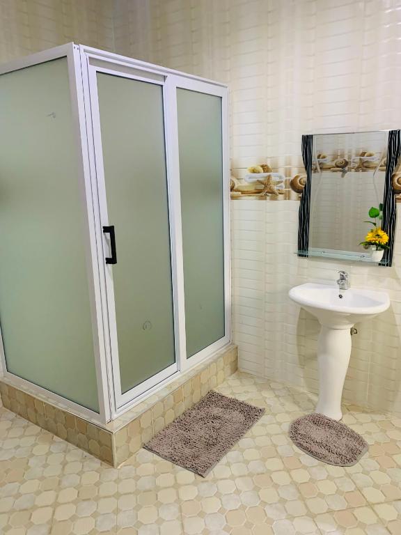 uma casa de banho com um chuveiro e um lavatório. em Apple Royal Apartments em Acra