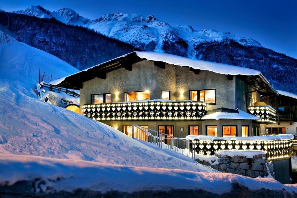a house in the snow at night at HEART - Manufaktur Appartements in Sölden