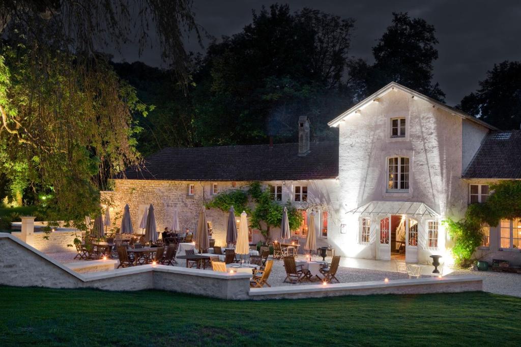 a house with an outdoor patio at night at Logis La Source Bleue in Gudmont