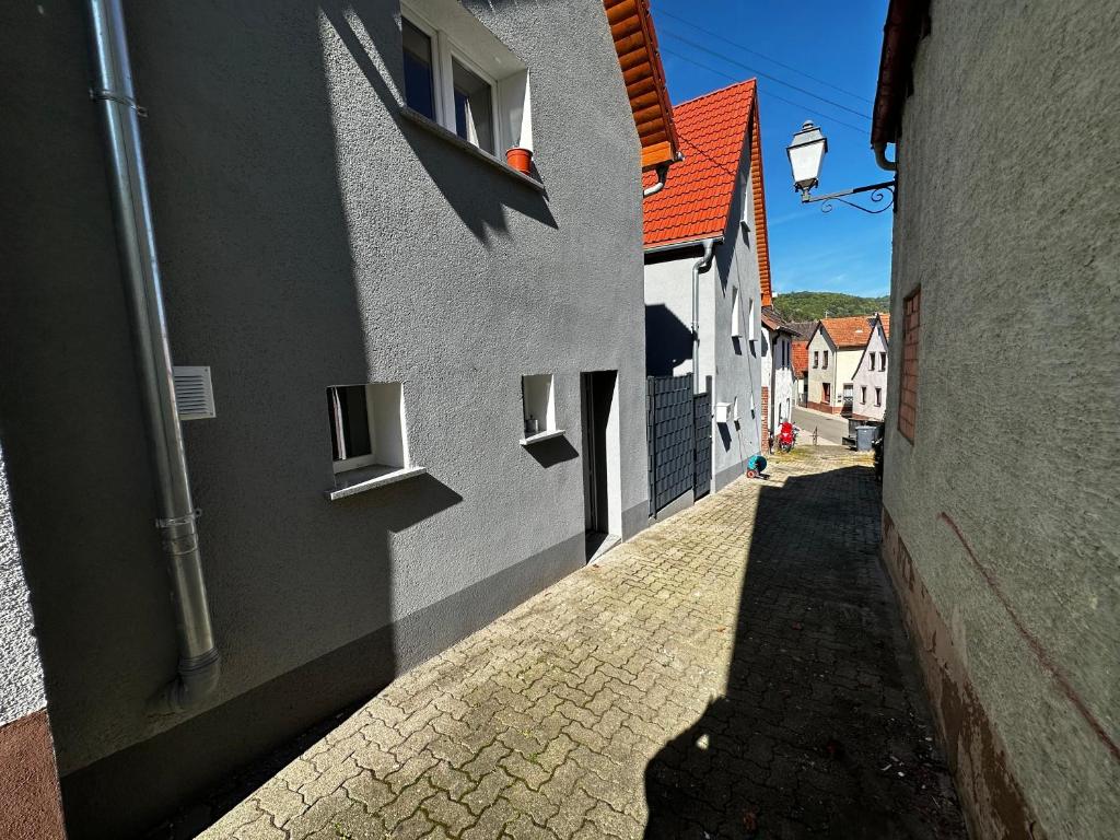 an alley between two buildings with a shadow on the ground at Dominik in Dernbach