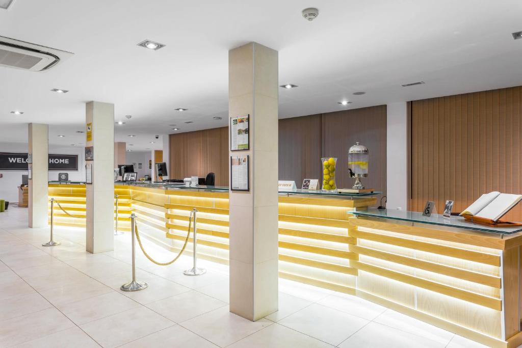 a lobby with a bar with yellow counter tops at Royal Sunset Beach Club in Adeje
