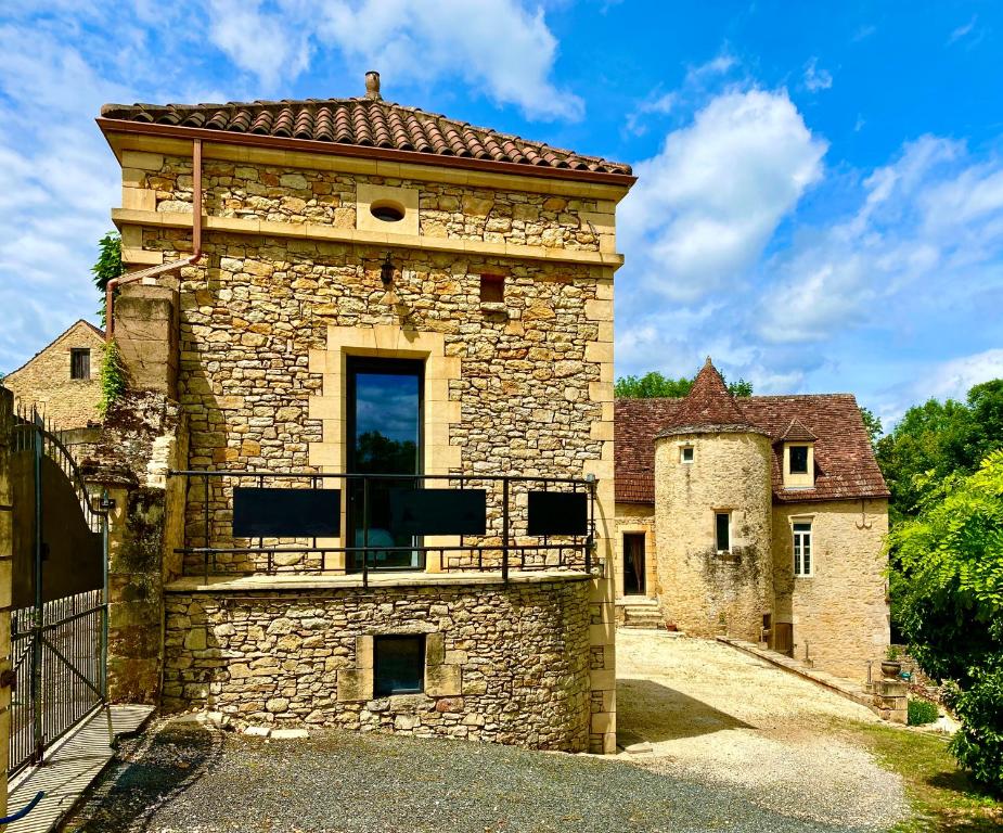 an old stone building with a red roof at Domaine des Mauves in Berbiguières