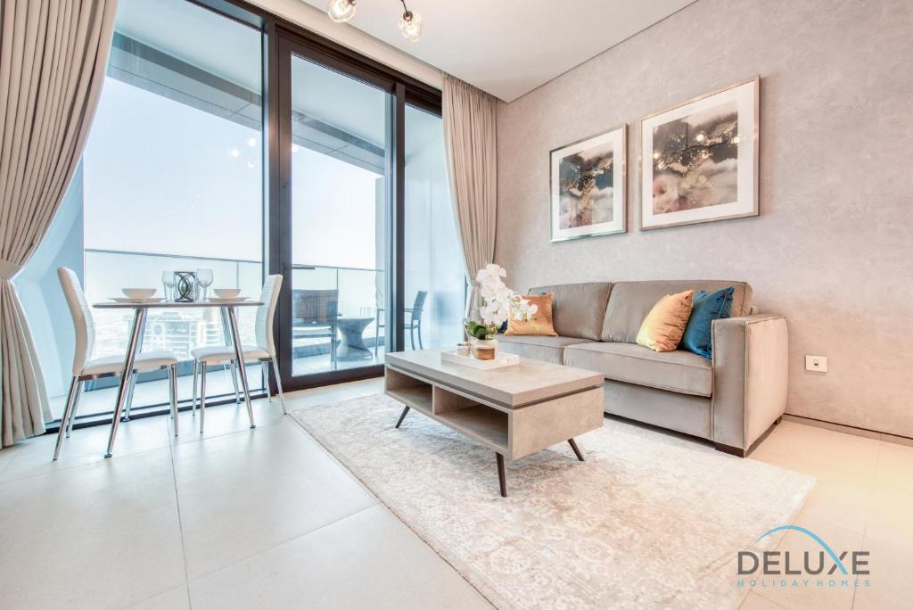 ein Wohnzimmer mit einem Sofa und einem Tisch in der Unterkunft Remarkable 1BR at The Address Residences in JBR by Deluxe Holiday Homes in Dubai