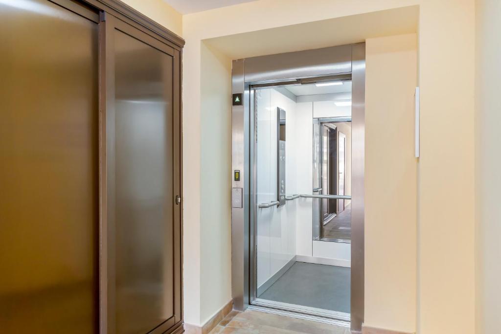 a glass shower door in a room with a mirror at Royal Sunset Beach Club in Adeje