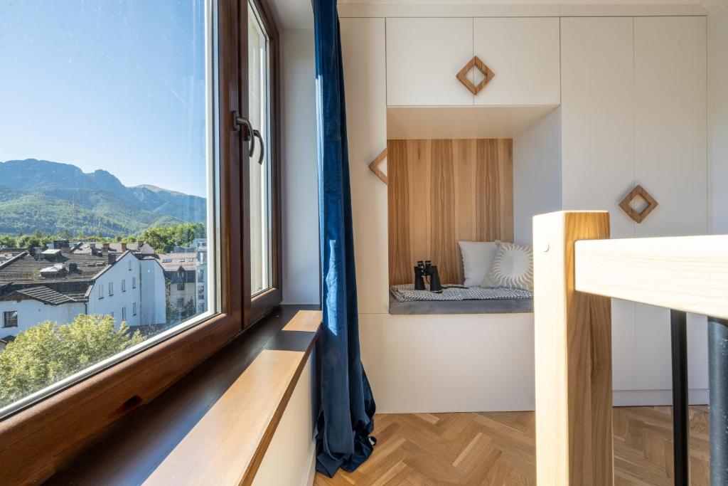 Zimmer mit einem Fenster und einem Bett mit Aussicht in der Unterkunft Studio Miła i Nido w Centrum APARTZAKOP in Zakopane