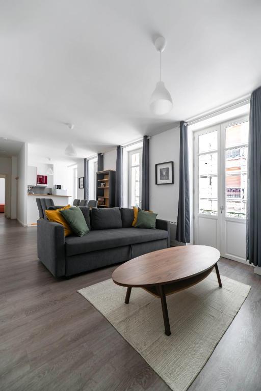 a living room with a couch and a coffee table at Le Brit - Grand appartement design, 3 chambres, centre ville in Vichy