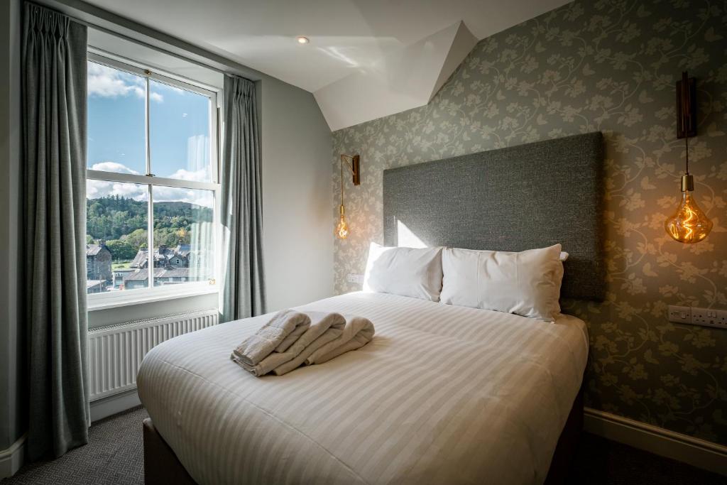 ein Schlafzimmer mit einem Bett mit zwei Handtüchern darauf in der Unterkunft Ambleside Fell Rooms in Ambleside