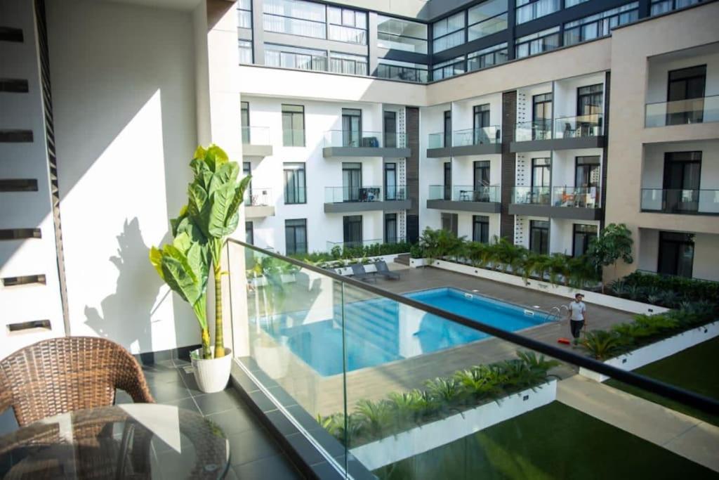 an apartment building with a swimming pool and a balcony at Paradise 1 bedroom Apartment @Embassy Gardens in Cantonments