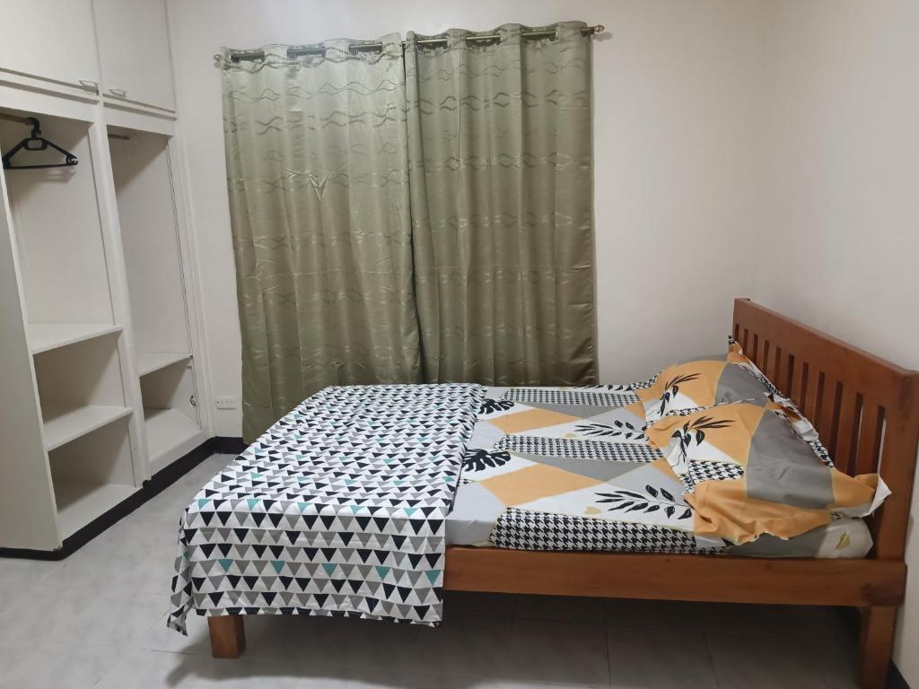 een slaapkamer met een bed en een gordijn bij EJA TRANSIENT HOUSE in Bacolod