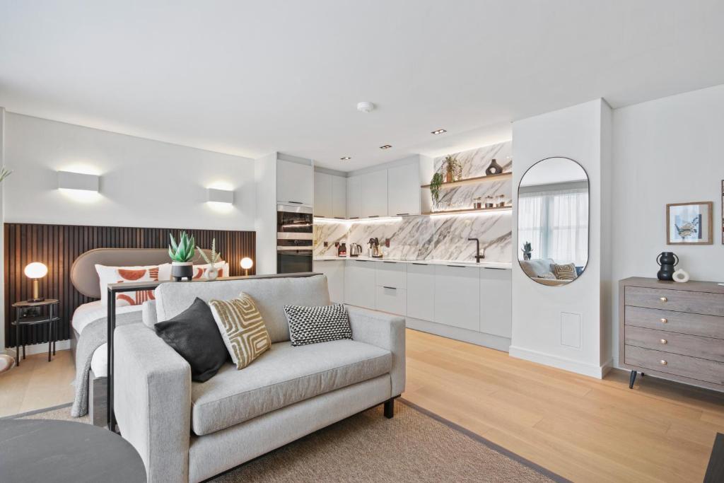 ein Wohnzimmer mit einem Sofa und einer Küche in der Unterkunft Bow Lane by Q Apartments in London
