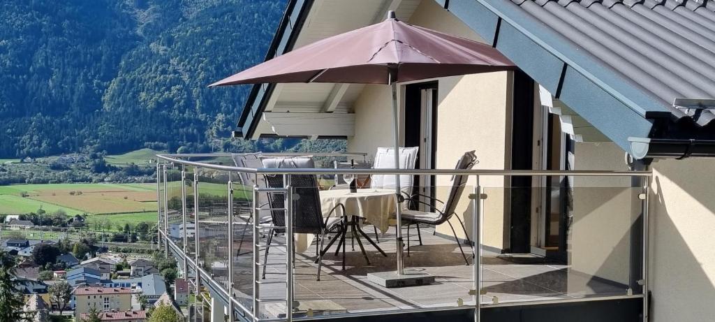 a balcony with a table and an umbrella at Ferienwohnung Pirker in Spittal an der Drau