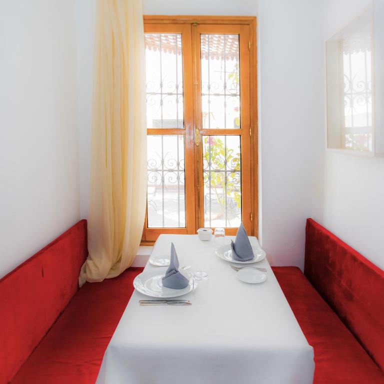 a white table with two chairs and a window at Hotel Blanco Riad in Tetouan
