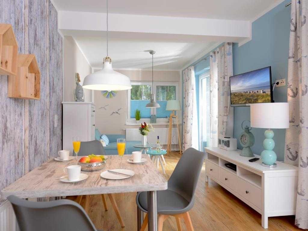 a dining room with a table and chairs in a room at Florida Haus am Strand in Boltenhagen