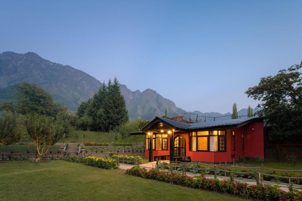 ein kleines rotes Haus mit Lichtern im Hof in der Unterkunft LohonoStays Red Cottage at Zaznar in Srinagar