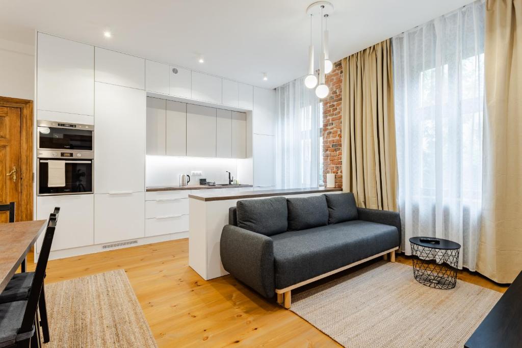 a living room with a couch and a kitchen at Two Bedroom Very Berry Apartment in Poznań with Desk by Noclegi Renters in Poznań