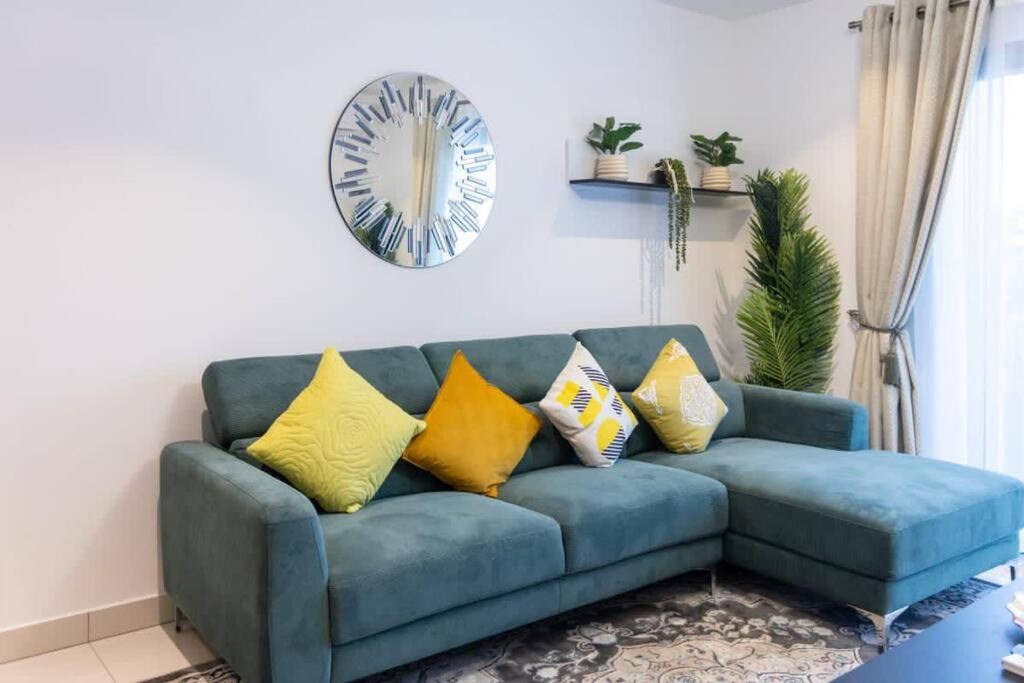 um sofá azul com almofadas amarelas numa sala de estar em Plush 1 Bedroom/Guest Washroom @The Lennox Airport em Acra