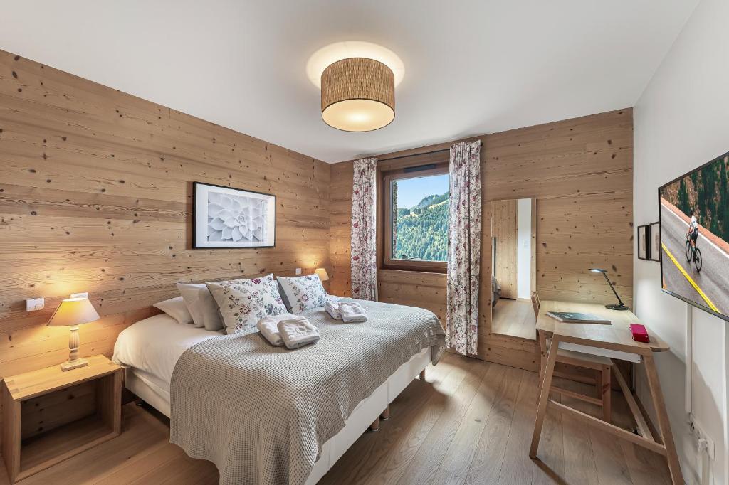 une chambre avec un lit, un bureau et une fenêtre dans l'établissement Les Flambeaux - Apt A13 - BO Immobilier - Châtel Multipass Été 2025 en option au tarif de 3euros par jour et par personne, à Châtel