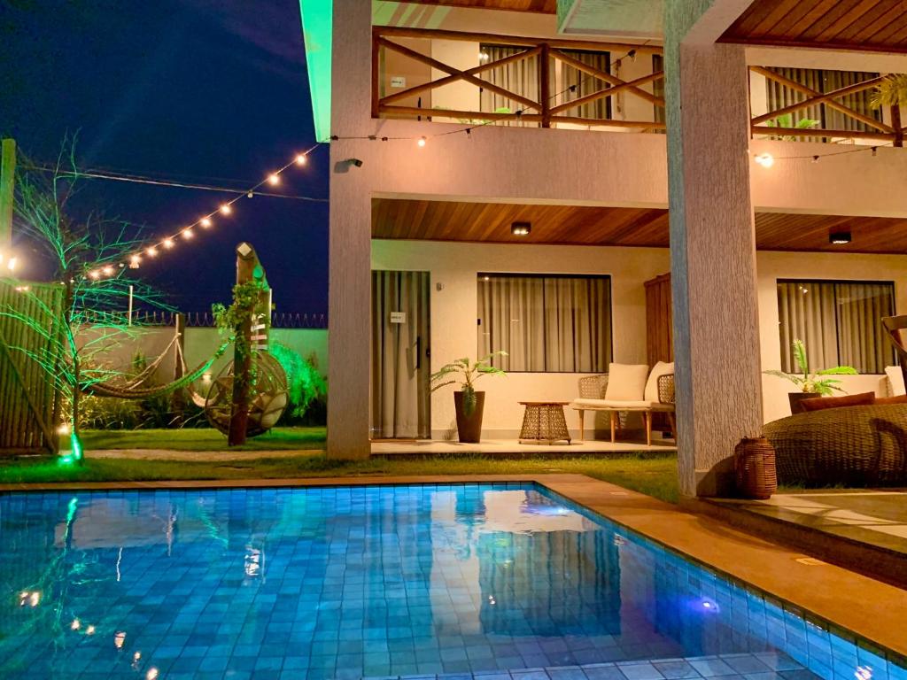 Villa con piscina por la noche en Pousada WOOD SUITES, en São Miguel do Gostoso