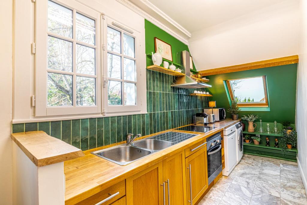 a kitchen with green walls and a sink at Double Appartements 2&amp;3 210 sqm up to 18 guests, Villa des Ammonites in Meudon