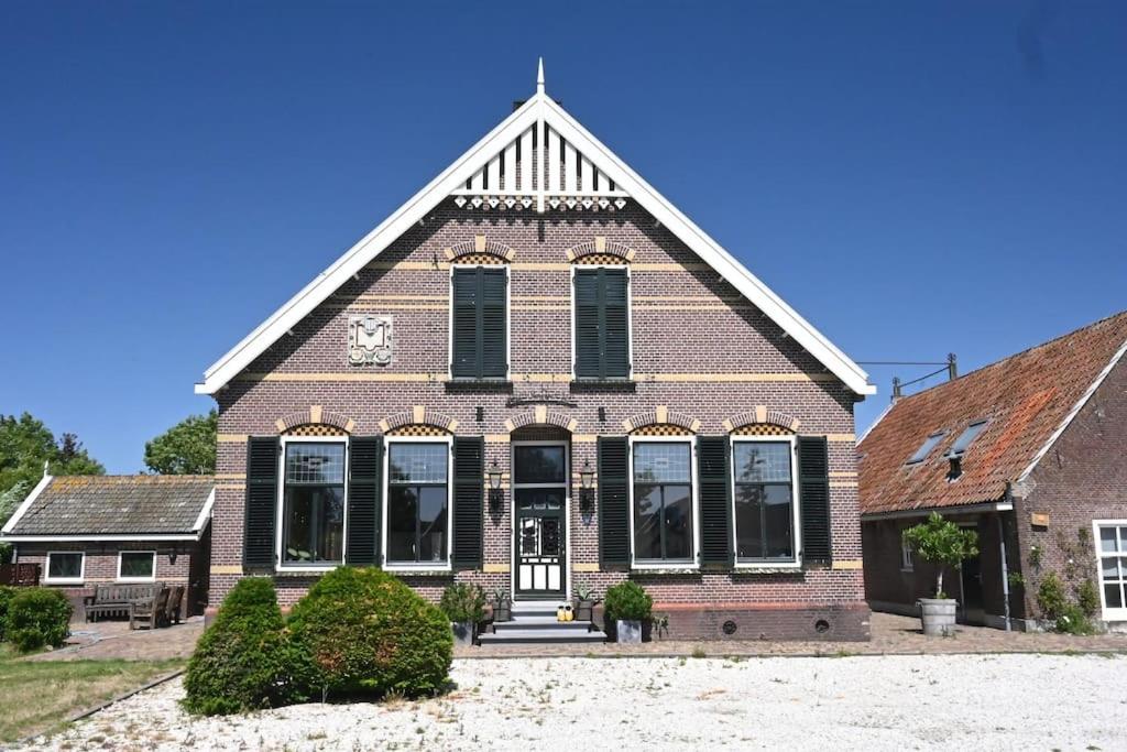 eine Kirche mit einer Uhr auf der Vorderseite in der Unterkunft Luxe woonboerderij in de natuur. in Nieuwkoop