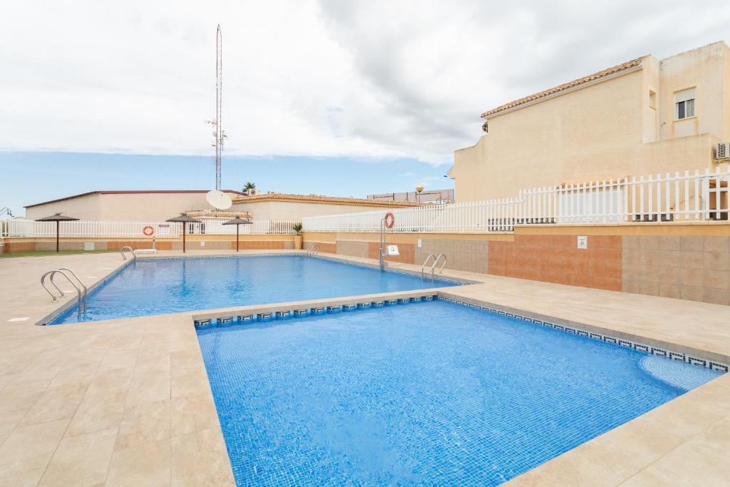 una grande piscina di fronte a un edificio di Bungalow 145 a Santa Pola