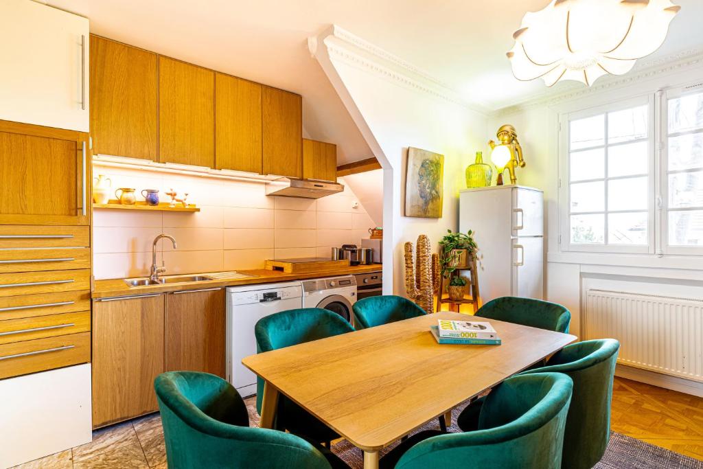 a kitchen with a wooden table and green chairs at Double Appartements 2&amp;3 210 sqm up to 18 guests, Villa des Ammonites in Meudon