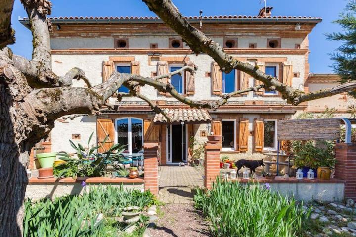 a house with a tree in front of it at Escapade dans la campagne toulousaine in Beaumont-sur-Lèze