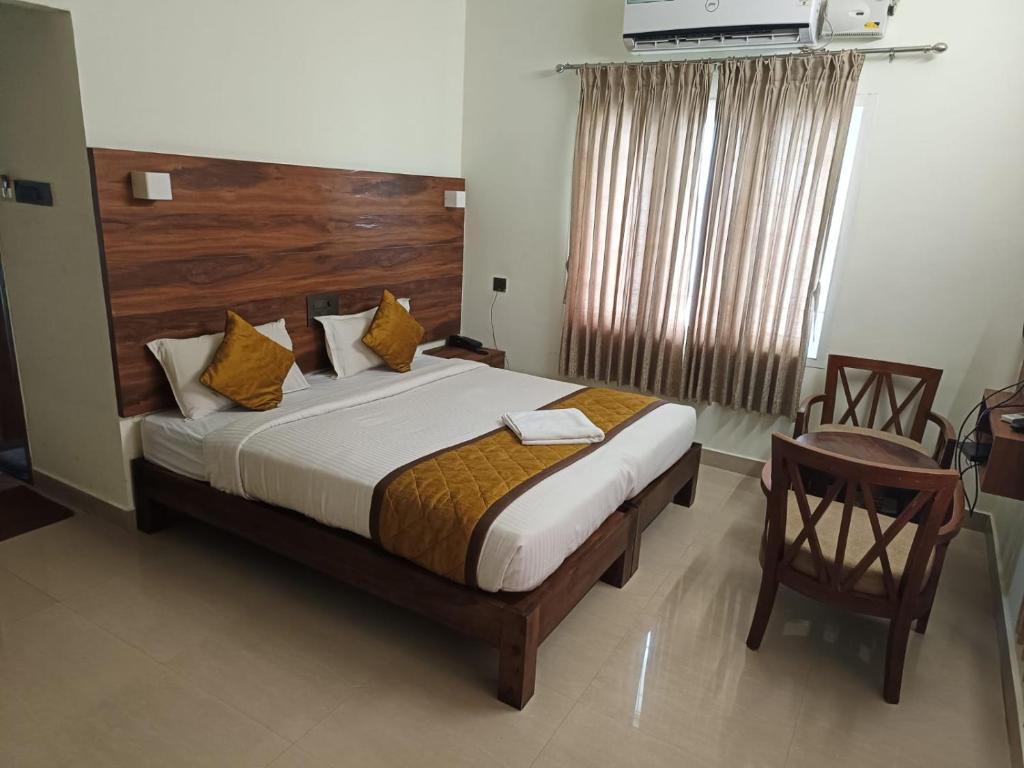 a bedroom with a large bed with a wooden headboard at PPH Living Athithi Inn Corporate Stay in Coimbatore