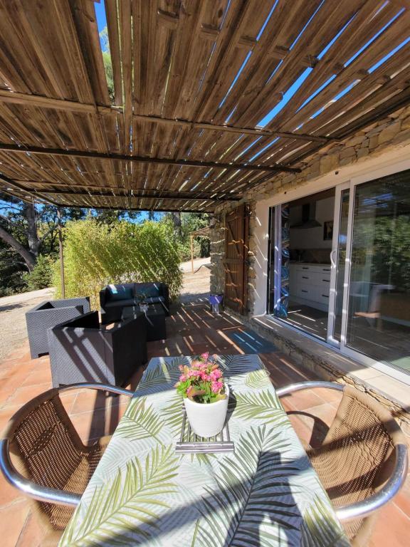 d'une terrasse avec une table et une plante en pot. dans l'établissement Studio dans maisonnette en pierre, au Castellet