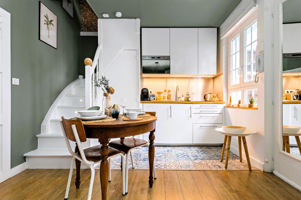 une salle à manger avec une table et une cuisine dans l'établissement La Souche, à Rouen