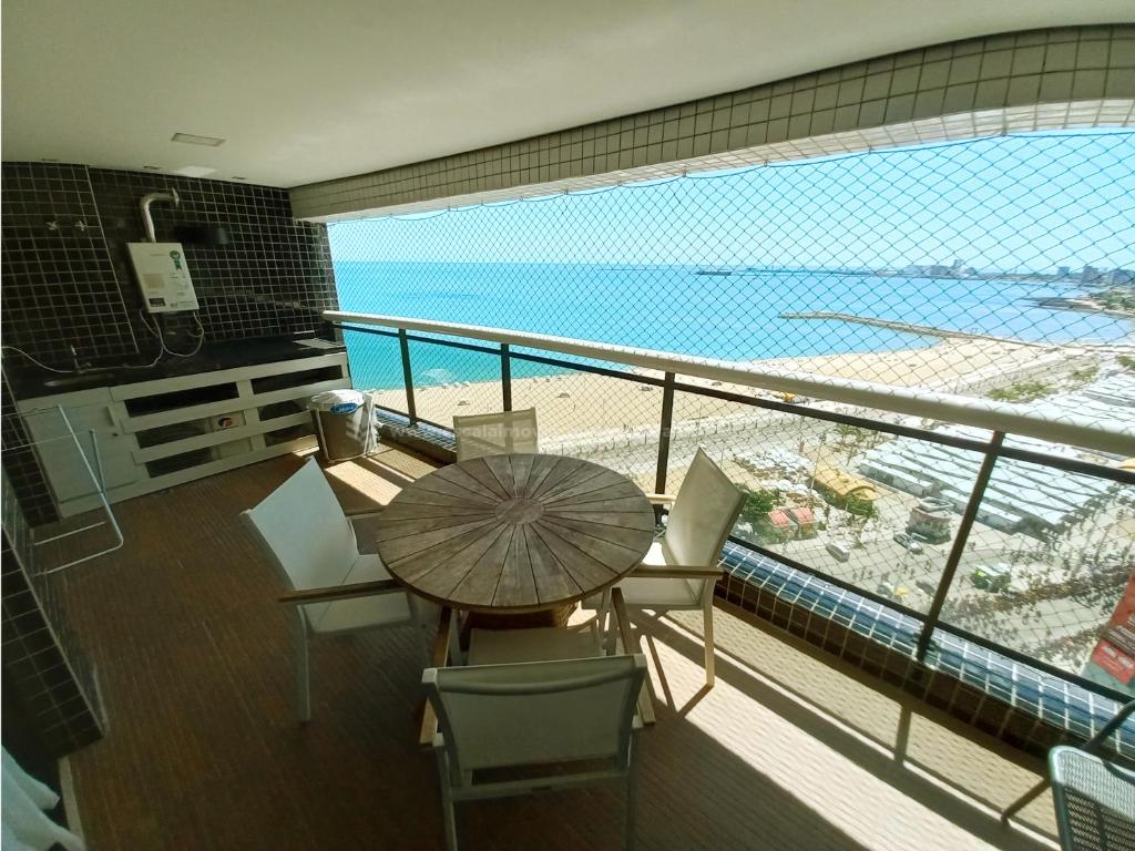 d'un balcon avec une table et des chaises et une vue sur la plage. dans l'établissement Escala Landscape Beira Mar, à Fortaleza