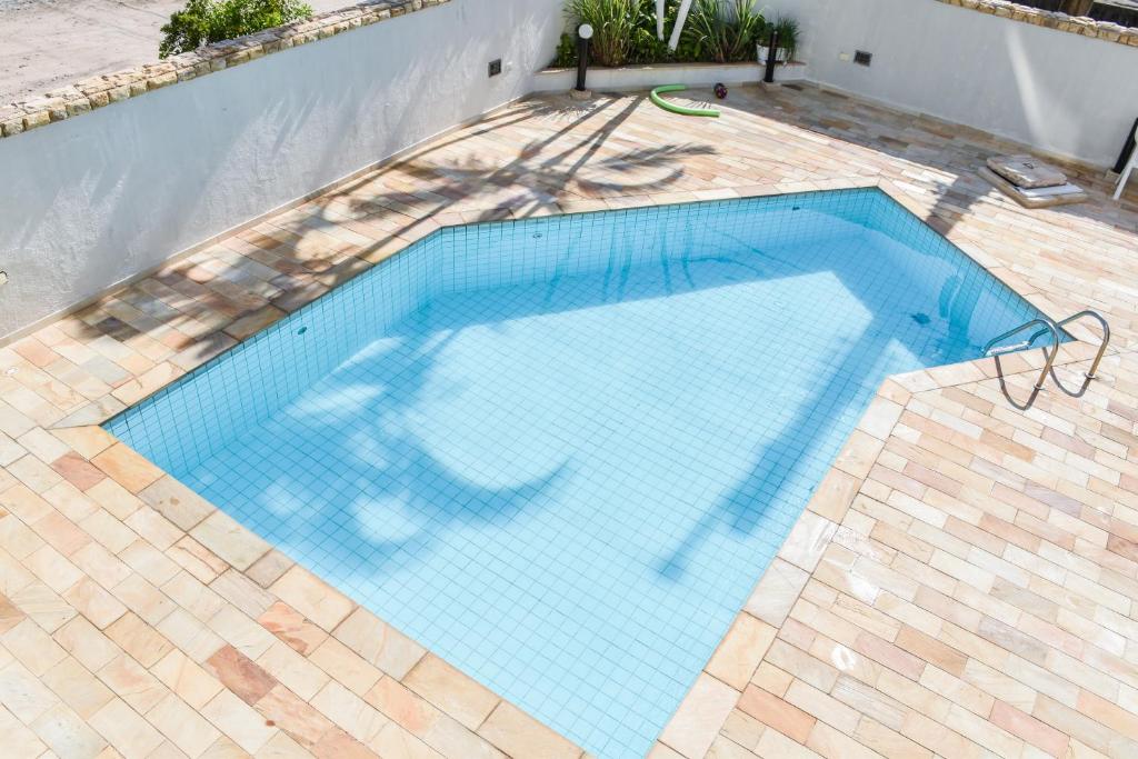 basen z niebieskimi płytkami na ziemi w obiekcie Apartarmento Ar Con - WIFI - Garagem - Piscina - Enseada Guarujá w mieście Guarujá