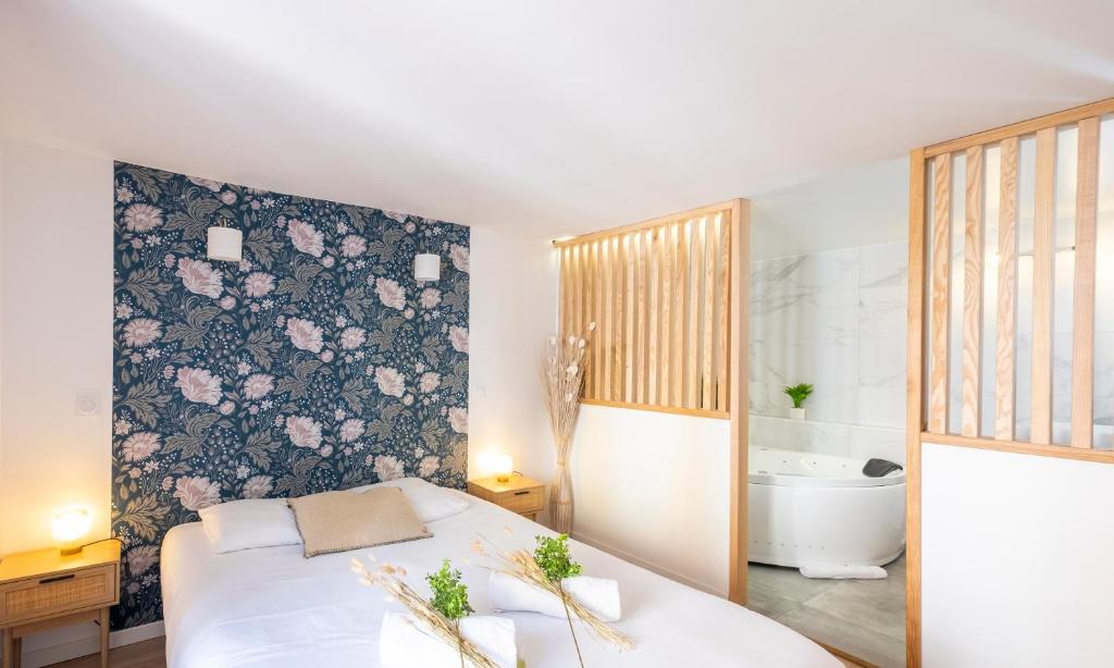 a bedroom with a bed with a floral wall at Petit cocon au centre d'Annecy in Annecy