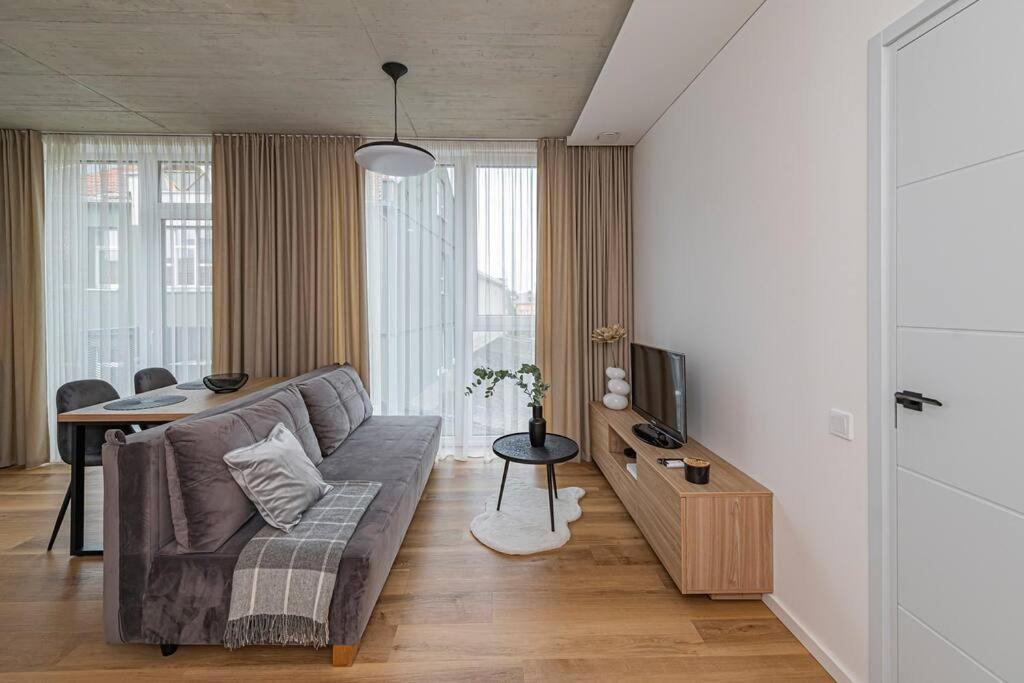 ein Wohnzimmer mit einem Sofa und einem Tisch in der Unterkunft Comfortable 1 BD Old Town Apartment by Hostlovers in Kaunas