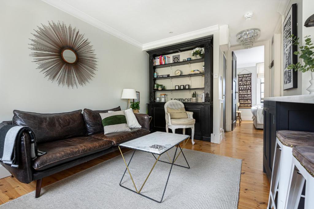 - un salon avec un canapé en cuir et une table dans l'établissement Lovely 1BR Flat, Prime Location Bloomsbury, Euston, à Londres