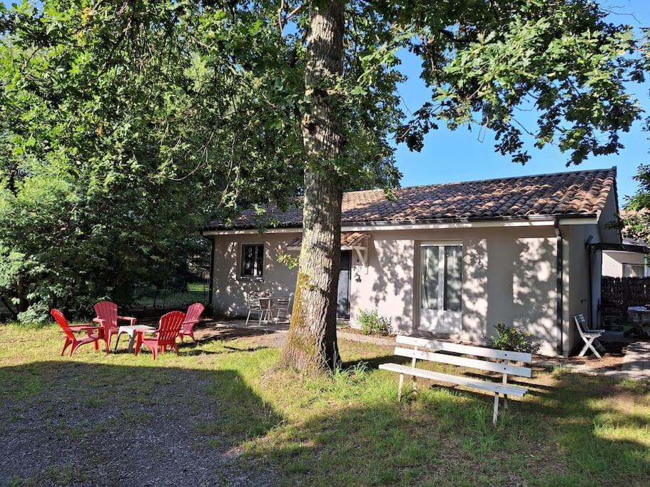 居讓梅斯特拉的住宿－Maison avec jardin au cœur du Bassin d'Arcachon，小屋配有红色椅子、桌子和一棵树