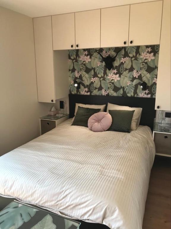 a bedroom with a large bed with a pink ball on it at La Bricole in Dinant