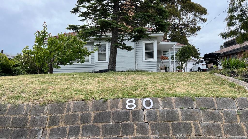 a house with a number on a brick wall at Charming House; Walk to Beach & Shops in Rosebud