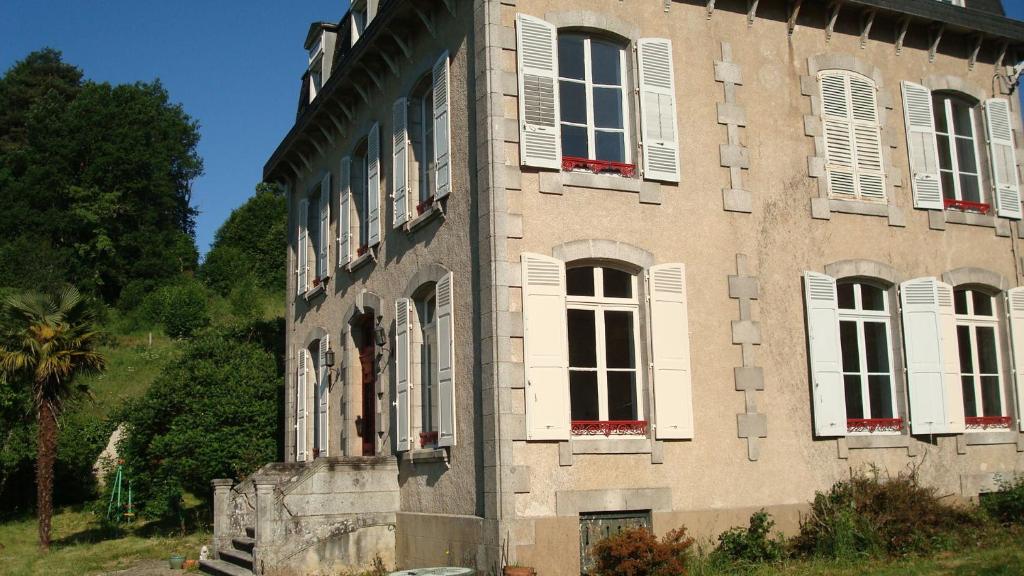 EymoutiersにあるLa Belle Maisonの白い窓の古い石造りの建物